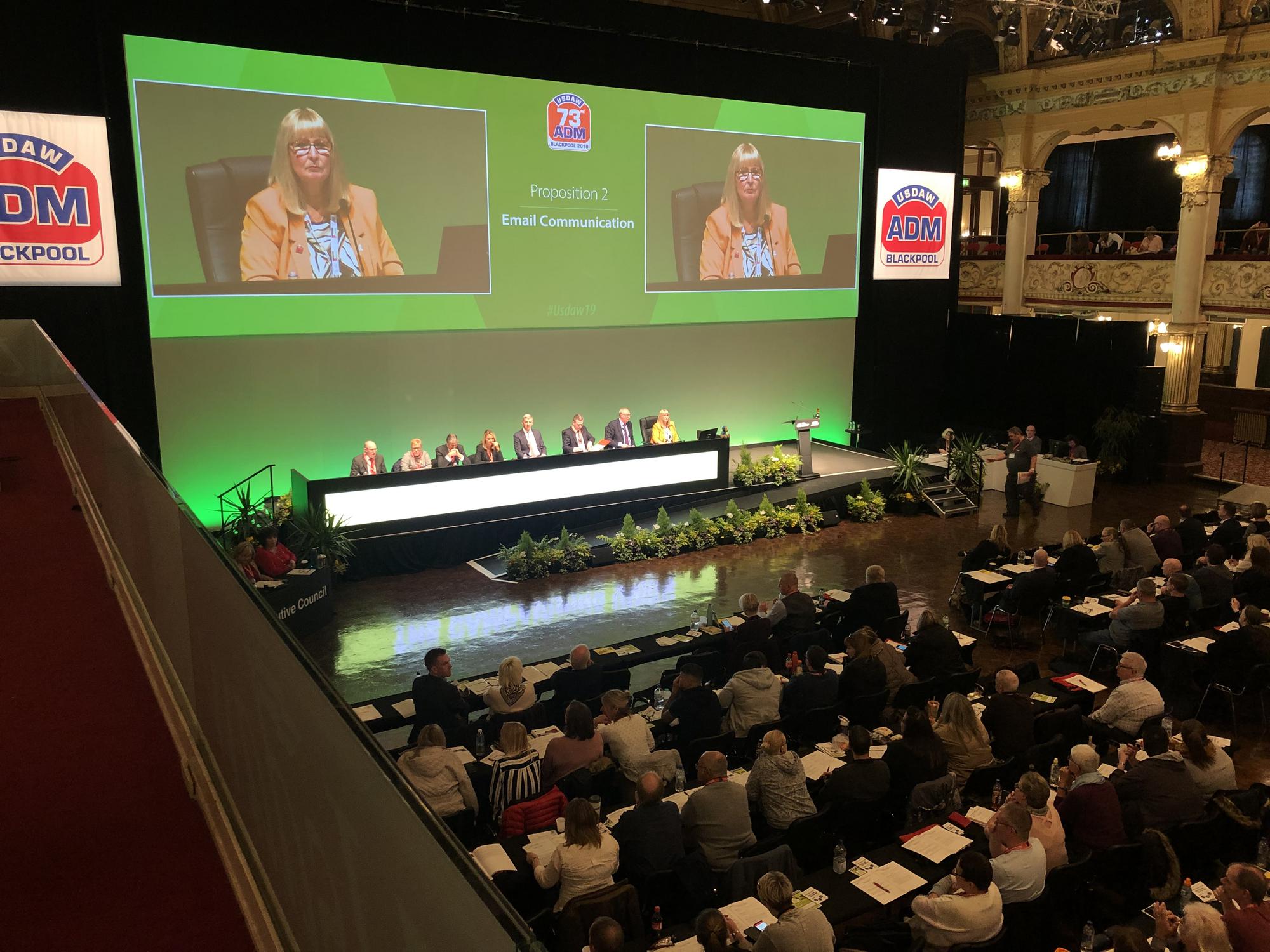 Whitney leaning against a railing on a downtown street