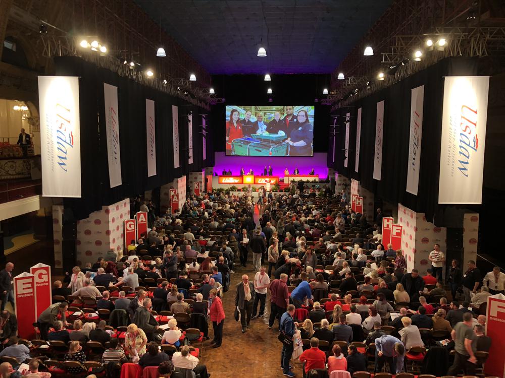 Whitney leaning against a railing on a downtown street